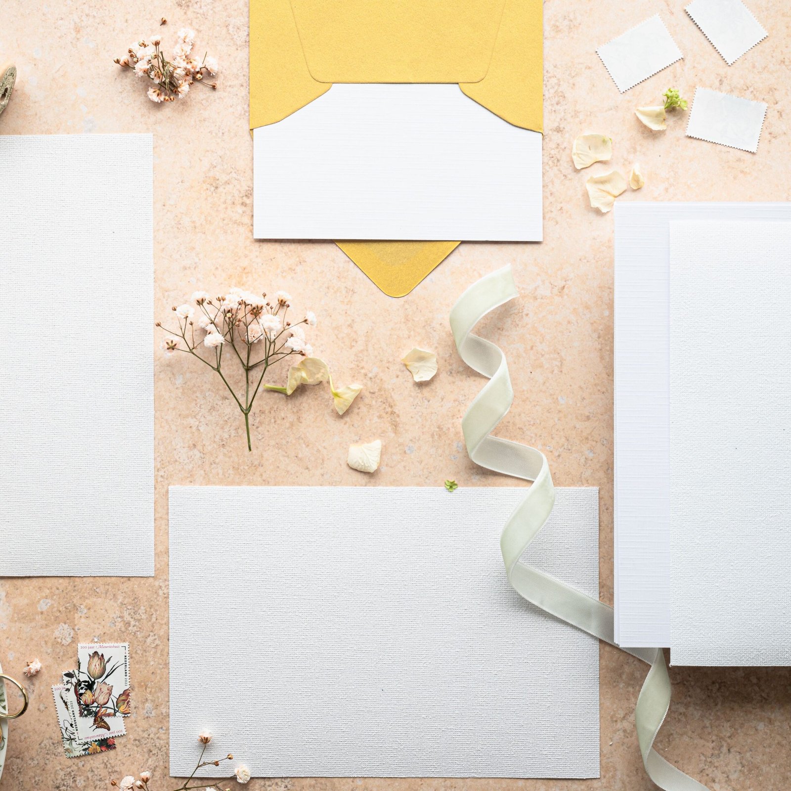 Flat lay of wedding invitation set with flowers and ribbon, perfect for elegant events.